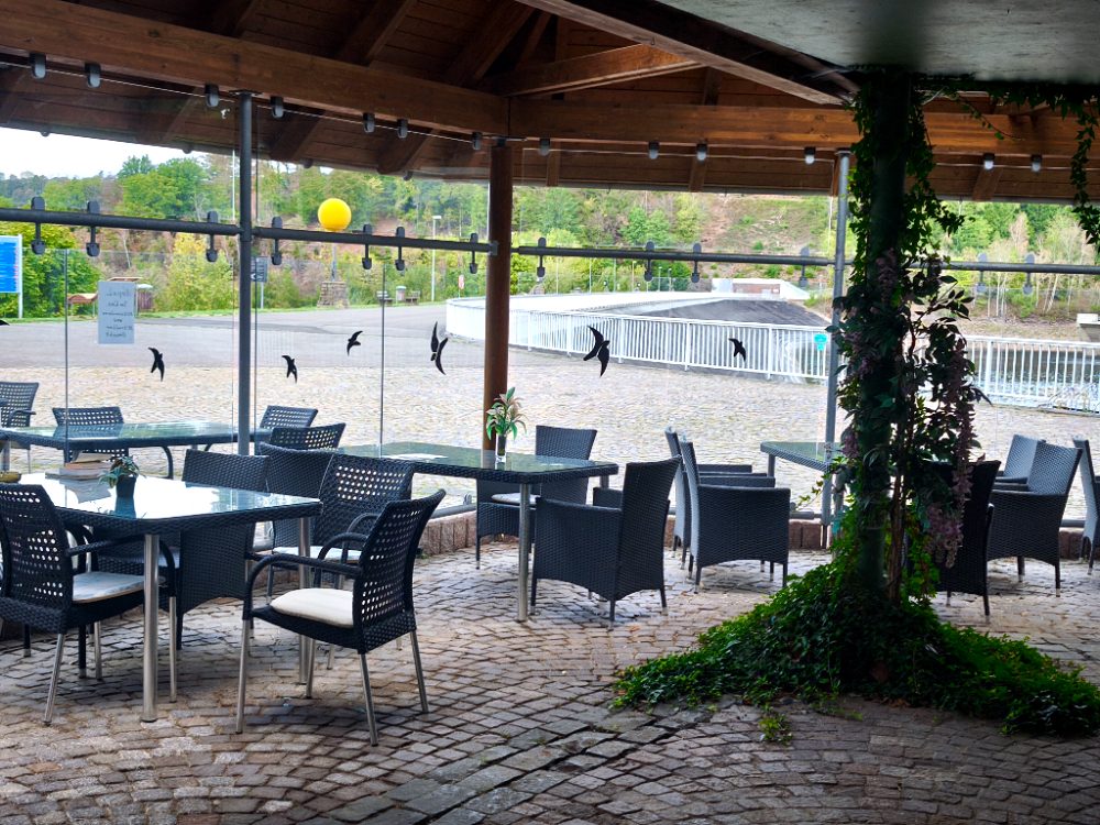 Überdachter Pavillon mit Tischen und Blick auf den Staudamm